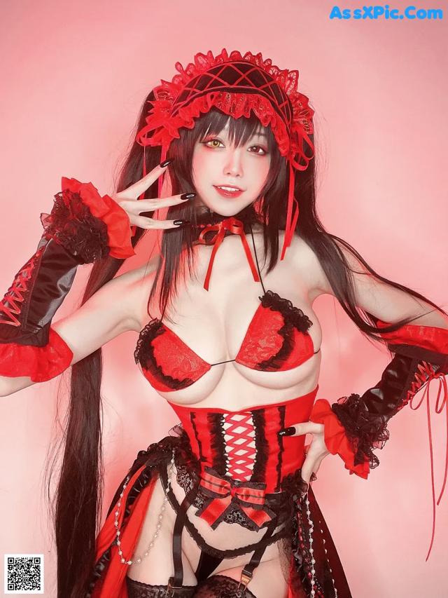 A woman in a red and black corset posing for a picture.