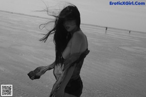 A woman in a red skirt standing on a beach.