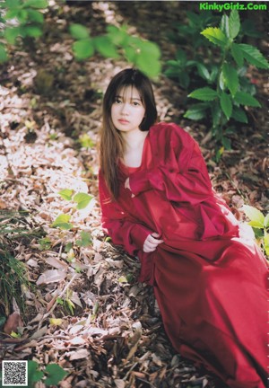 A woman with long brown hair wearing a white shirt.