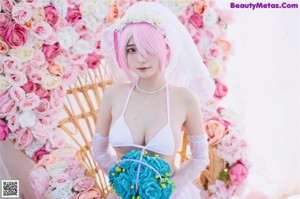 A woman in a wedding dress making a heart with her hands.