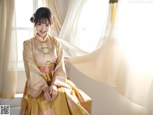 A naked asian woman in a blue kimono posing for the camera.