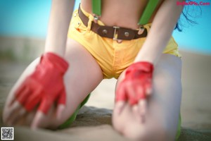 A woman in a green top and yellow shorts posing for a picture.