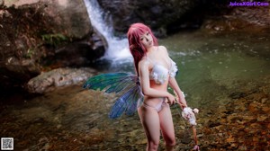 A woman in a white lingerie sitting on a rock.