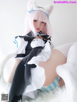A woman in a maid outfit is posing for a picture.