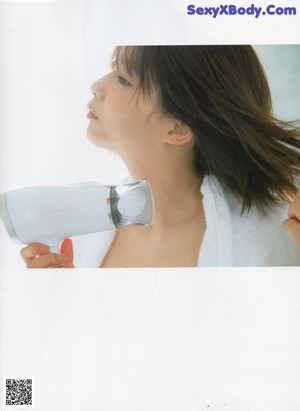 A woman in a white sweater sitting on a window sill.