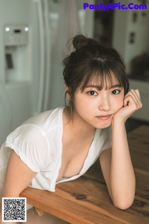 A woman sitting on top of a wooden chair.