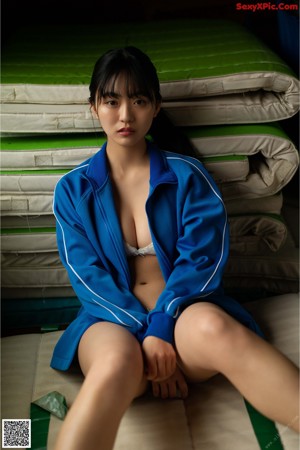 A woman in a blue bikini sitting on a wooden bench.