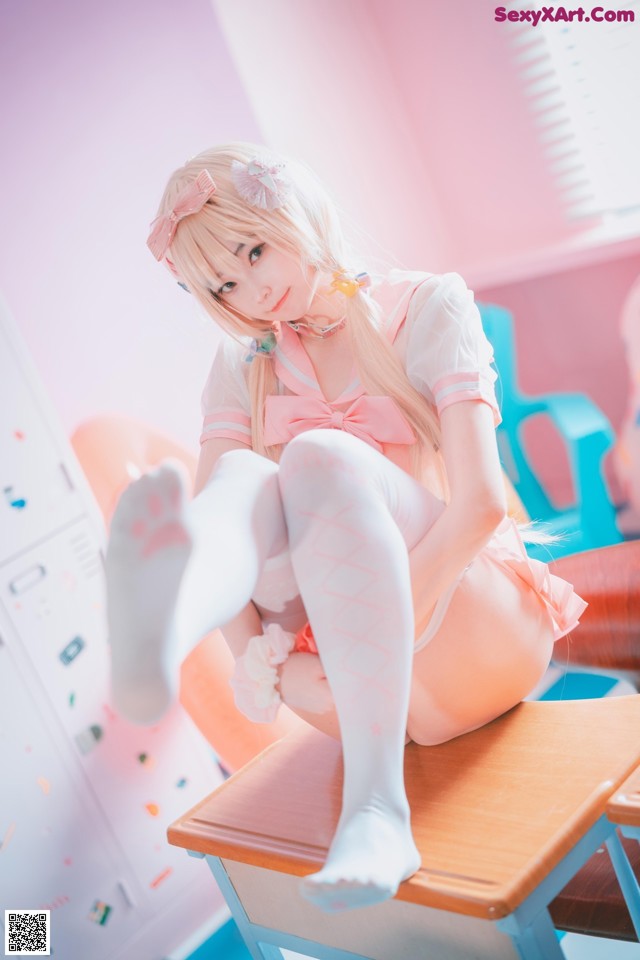 A woman sitting on top of a desk in a room.