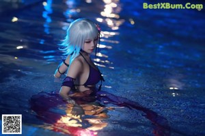 A woman in a black bikini sitting on a chair.