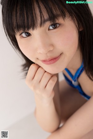 A woman in a blue and white bikini posing for a picture.