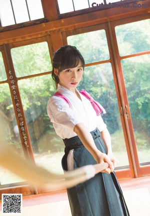 A woman wearing a scarf standing next to a wooden bench.