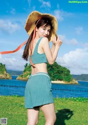 A woman in a straw hat is posing for a picture.
